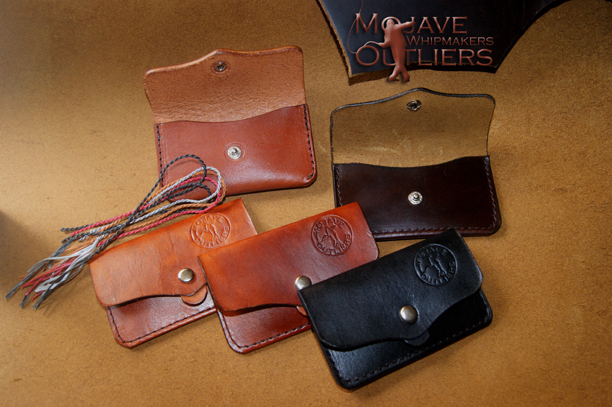 Flip side of the cracker cases, showing the maker's mark and snap closure reinforced with a leather pull tab.